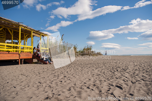 Image of Group of friends having fun on autumn day at beach