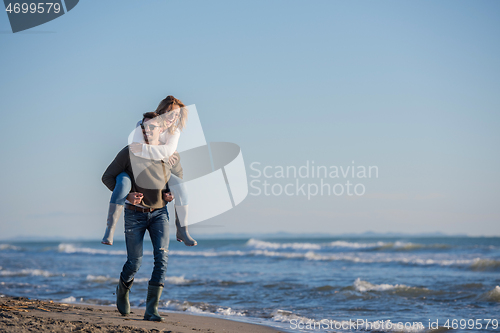 Image of couple having fun at beach during autumn