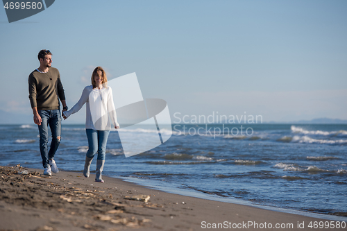 Image of Loving young couple on a beach at autumn sunny day