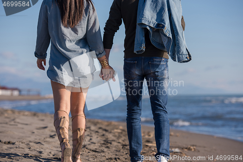 Image of Loving young couple on a beach at autumn sunny day