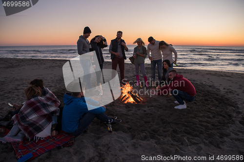 Image of Friends having fun at beach on autumn day