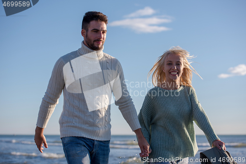 Image of Loving young couple on a beach at autumn sunny day