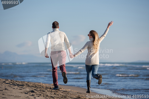 Image of Loving young couple on a beach at autumn sunny day