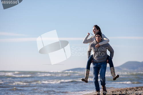 Image of couple having fun at beach during autumn