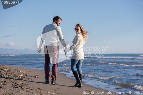 Image of Loving young couple on a beach at autumn sunny day