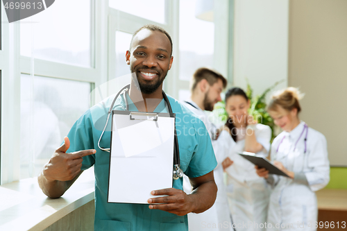 Image of Beautiful smiling african doctor over hospital background