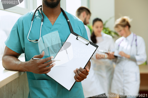 Image of Beautiful smiling african doctor over hospital background