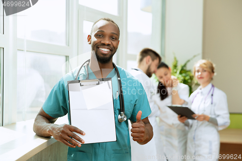 Image of Beautiful smiling african doctor over hospital background