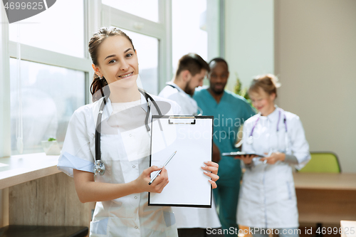 Image of Beautiful smiling doctor over hospital background