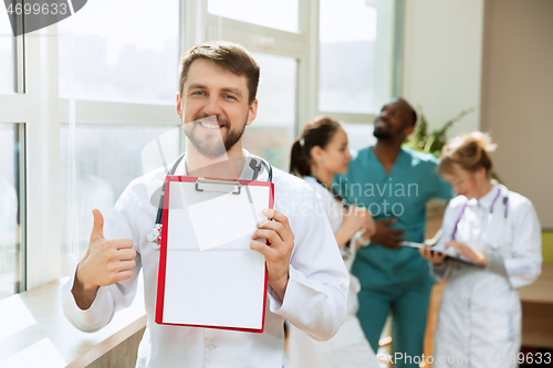 Image of Beautiful smiling doctor over hospital background