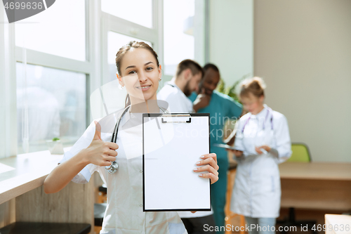 Image of Beautiful smiling doctor over hospital background