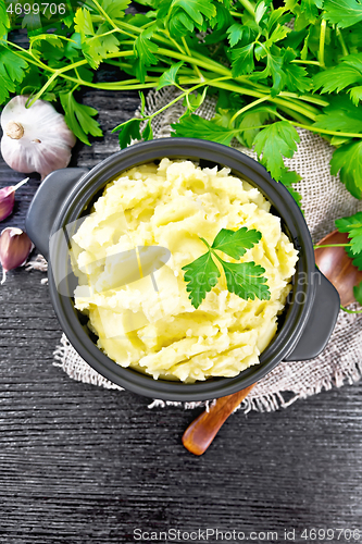 Image of Potatoes mashed in saucepan on dark board top