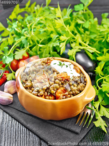 Image of Lentils with eggplant and tomatoes in bowl on napkin 