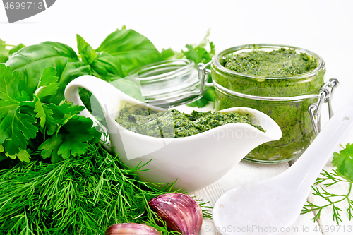 Image of Sauce of spicy greens in gravy boat and jar on light board