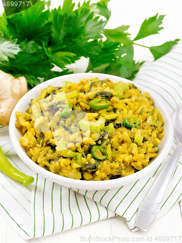 Image of Kitchari with celery in bowl on white board