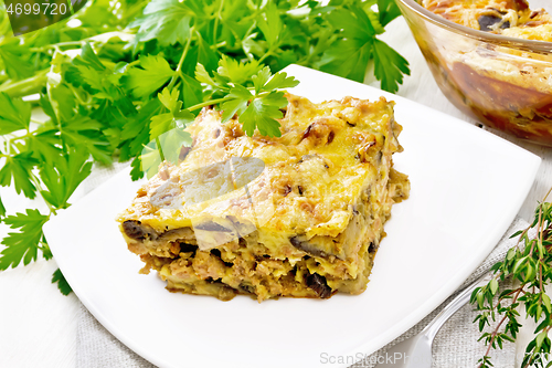 Image of Casserole of meat and eggplant in plate on light board