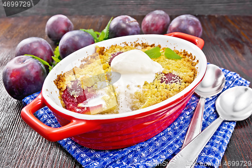 Image of Crumble with plum and ice cream in brazier on board