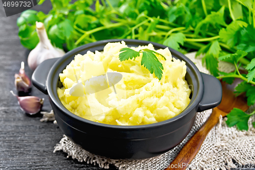 Image of Potatoes mashed in saucepan on board
