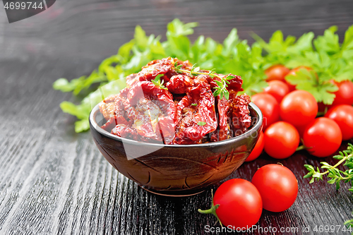 Image of Tomatoes sun-dried in bowl on dark board