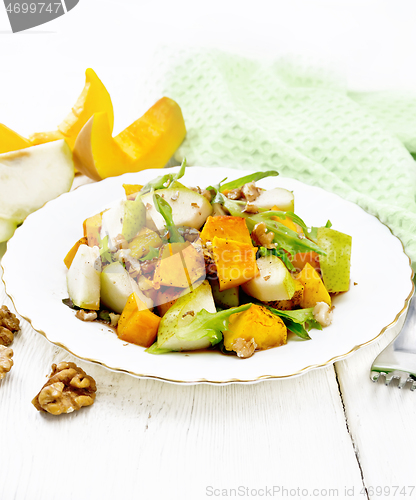 Image of Salad of pumpkin and pear in plate on wooden board