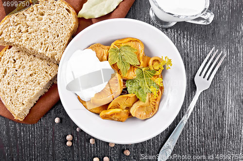 Image of Mushrooms salted with sour cream in plate on board top