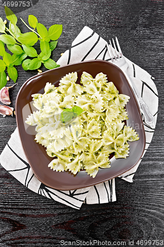 Image of Farfalle with pesto in plate on black board top