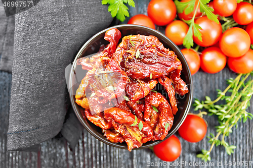 Image of Tomatoes sun-dried in bowl with napkin on board top