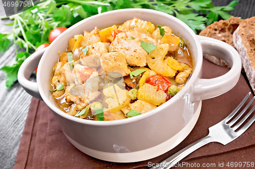 Image of Chicken with vegetables and peas in saucepan on board