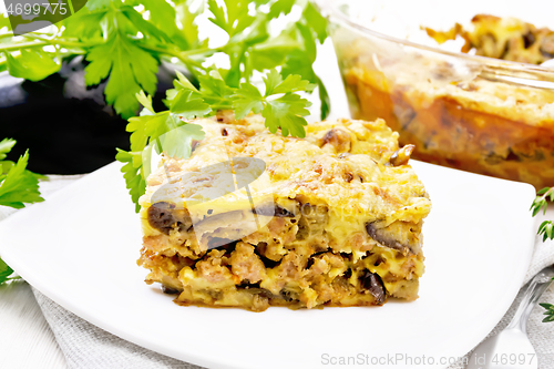 Image of Casserole of meat and eggplant in plate on wooden board