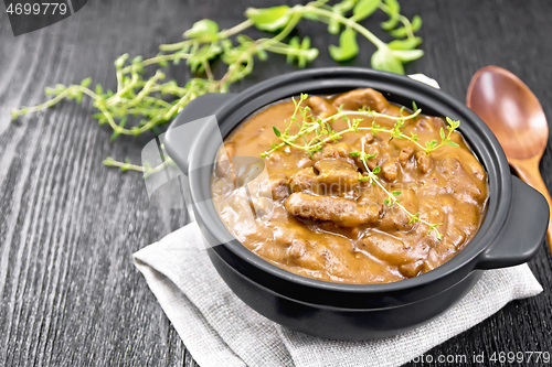 Image of Goulash of beef in pan on wooden board