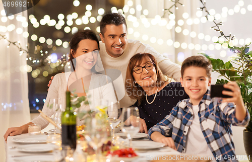 Image of family having dinner party and taking selfie