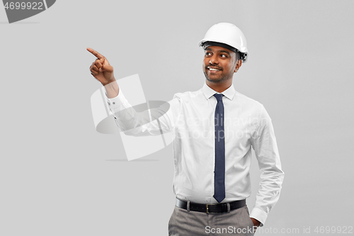 Image of indian male architect in helmet showing something