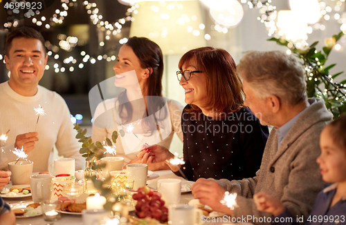 Image of family with sparklers having tea party at home