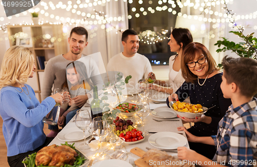 Image of happy family having dinner party at home