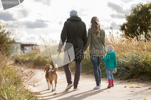 Image of happy family walking with dog in autumn