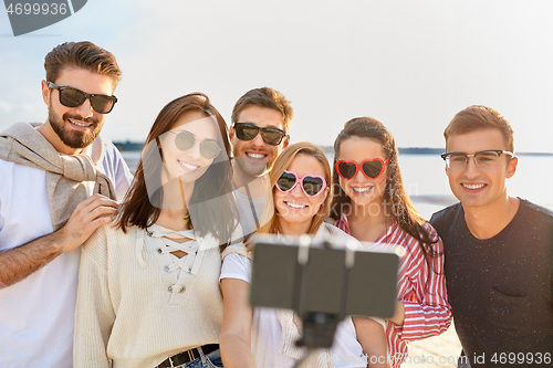 Image of happy friends taking selfie on summer beach