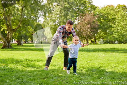 Image of happy father with son playing in summer park