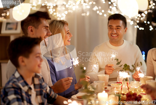 Image of family with sparklers having tea party at home