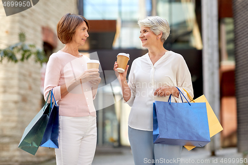 Image of senior women with shopping bags and coffee in city