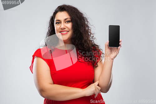 Image of happy woman in red dress showing smartphone