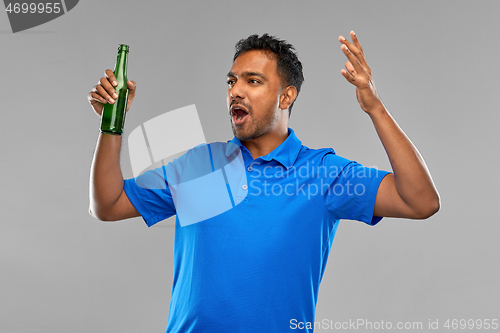 Image of emotional indian man or sports fan beer bottle