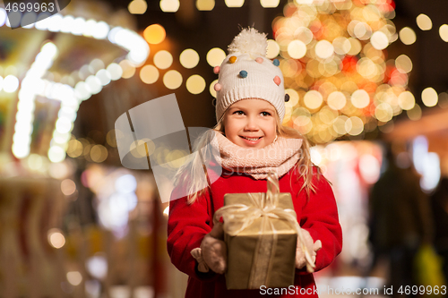 Image of happy girl with gift box at christmas market