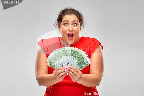 Image of shocked woman holding hundreds of money banknotes