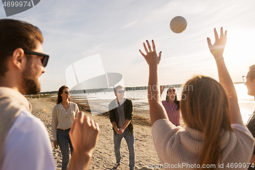 Image of friends playing volleyball on beach in summer