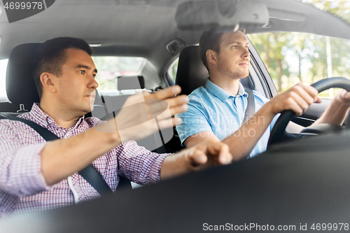 Image of car driving school instructor teaching male driver