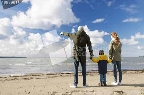 Image of happy family at autumn beach looking at sea