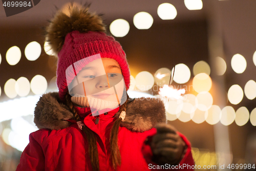 Image of happy girl with sparkler at christmas market