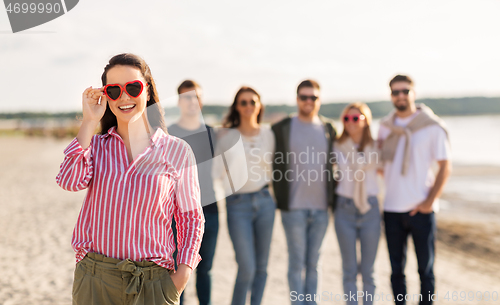 Image of happy woman with friends on beach in summer