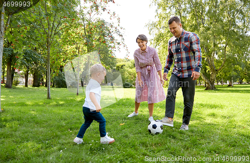 Image of happy family playing soccer at summer park