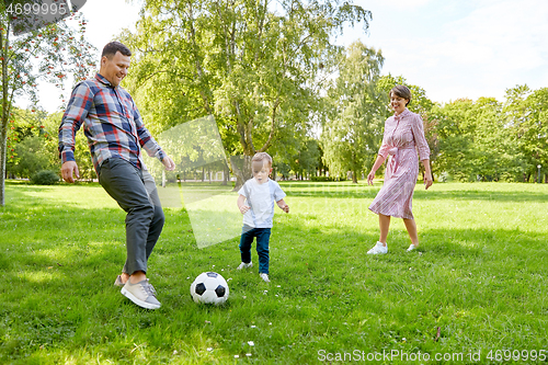 Image of happy family playing soccer at summer park